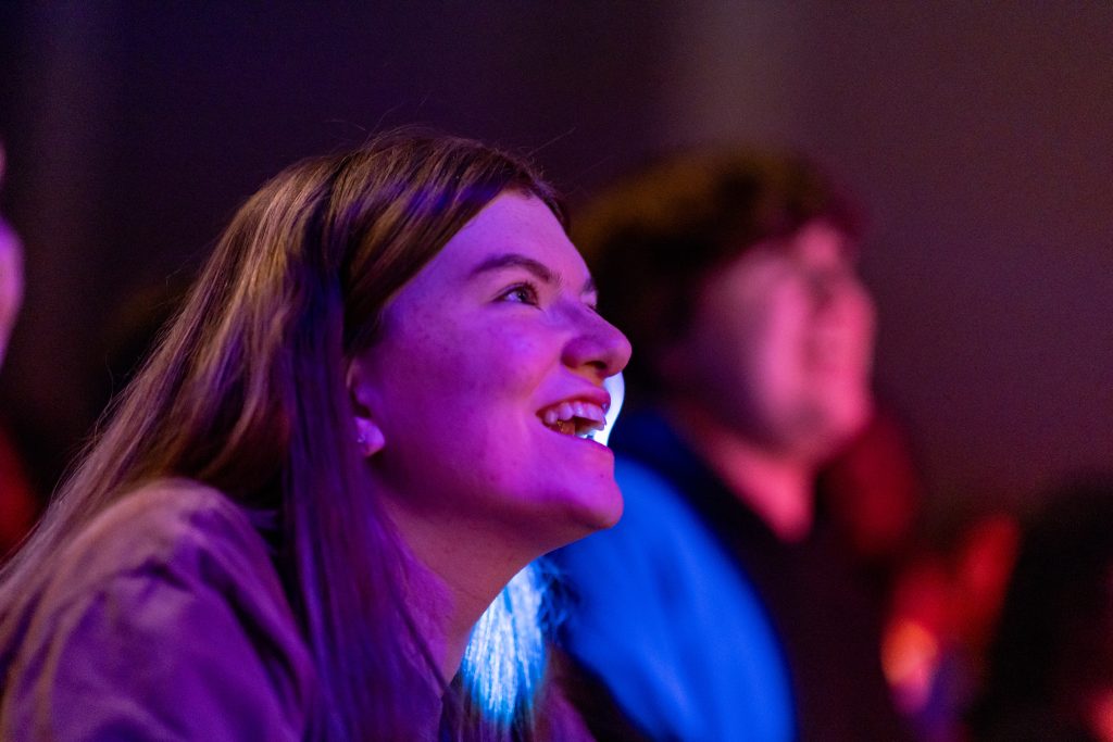 Woman laughs with colored background