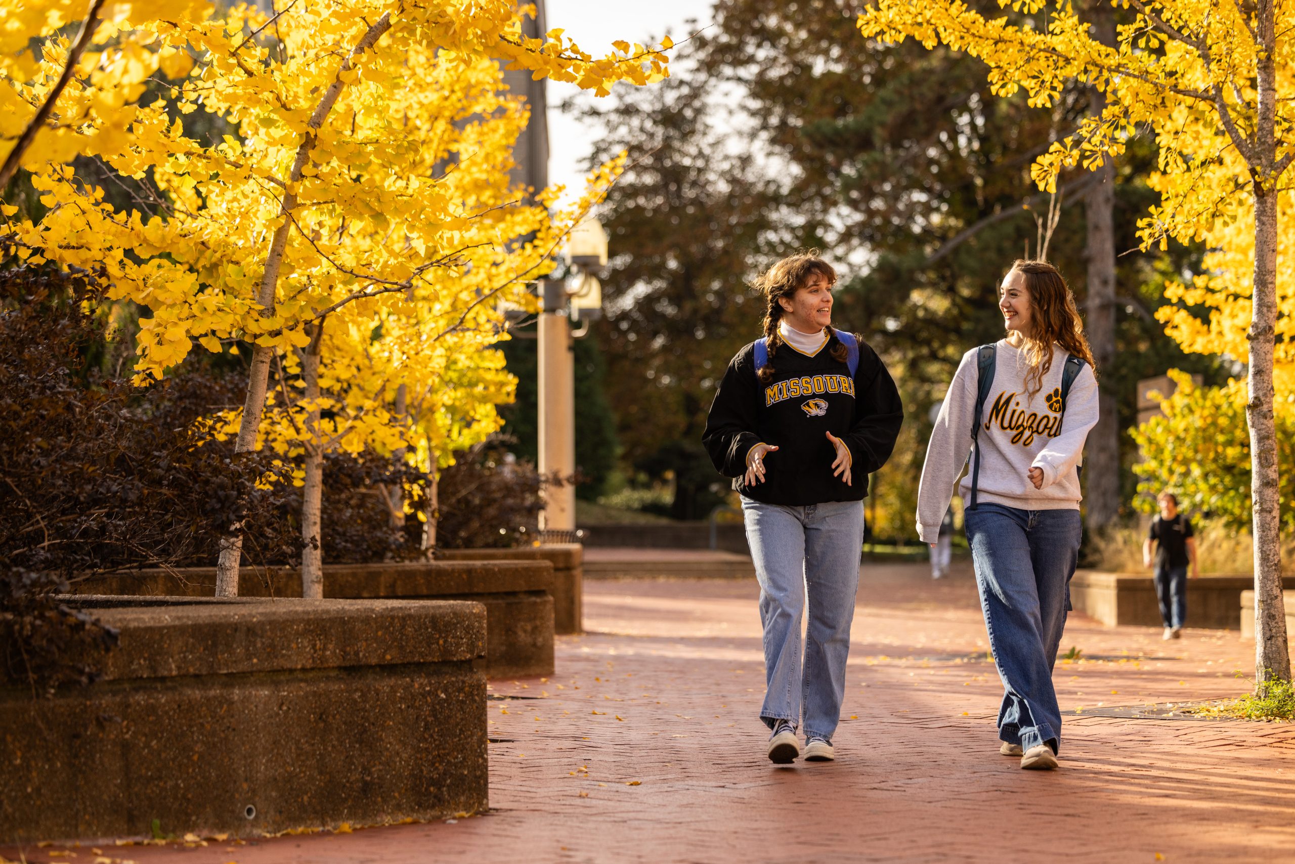Two students walk across Lowry Mall