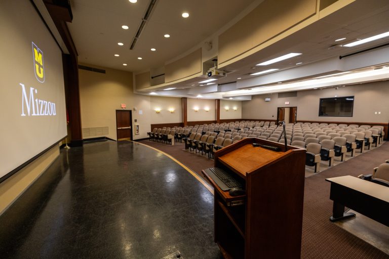 Large auditorium space with chairs, stage and projector stage