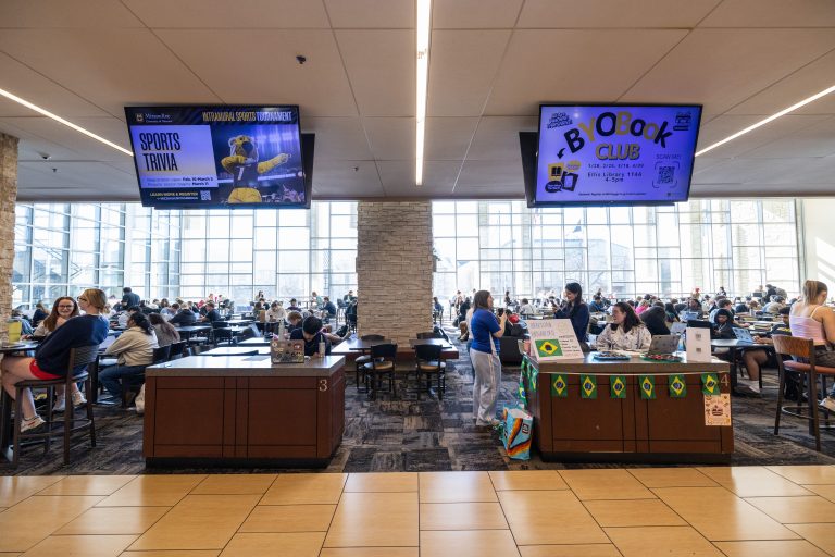 Information tables with televisions above them in the student center
