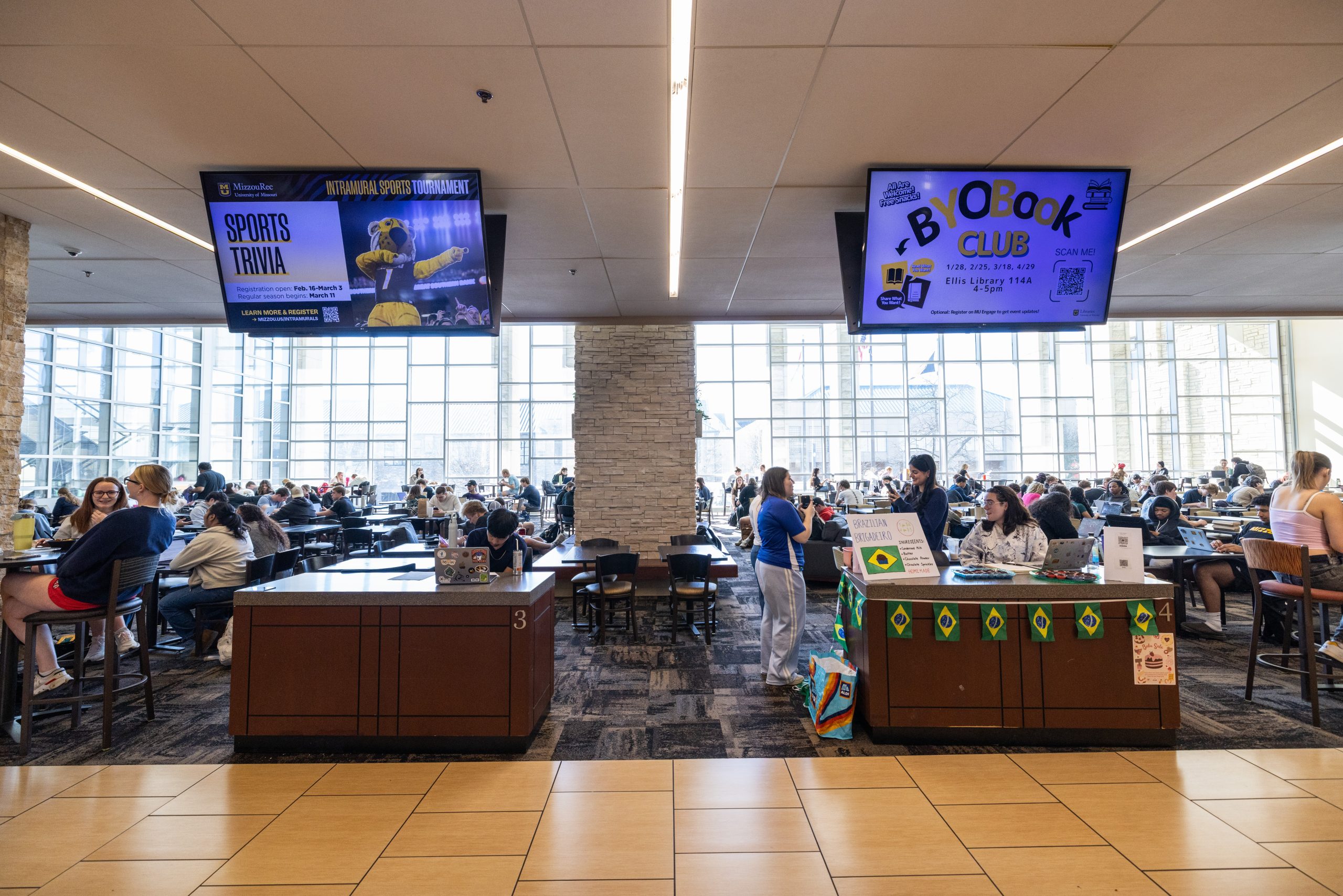 Information tables with televisions above them in the student center