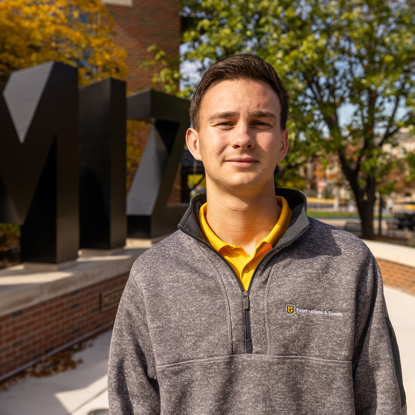 Logan Greenplate at the M-I-Z statue at Reynolds Alumni Center